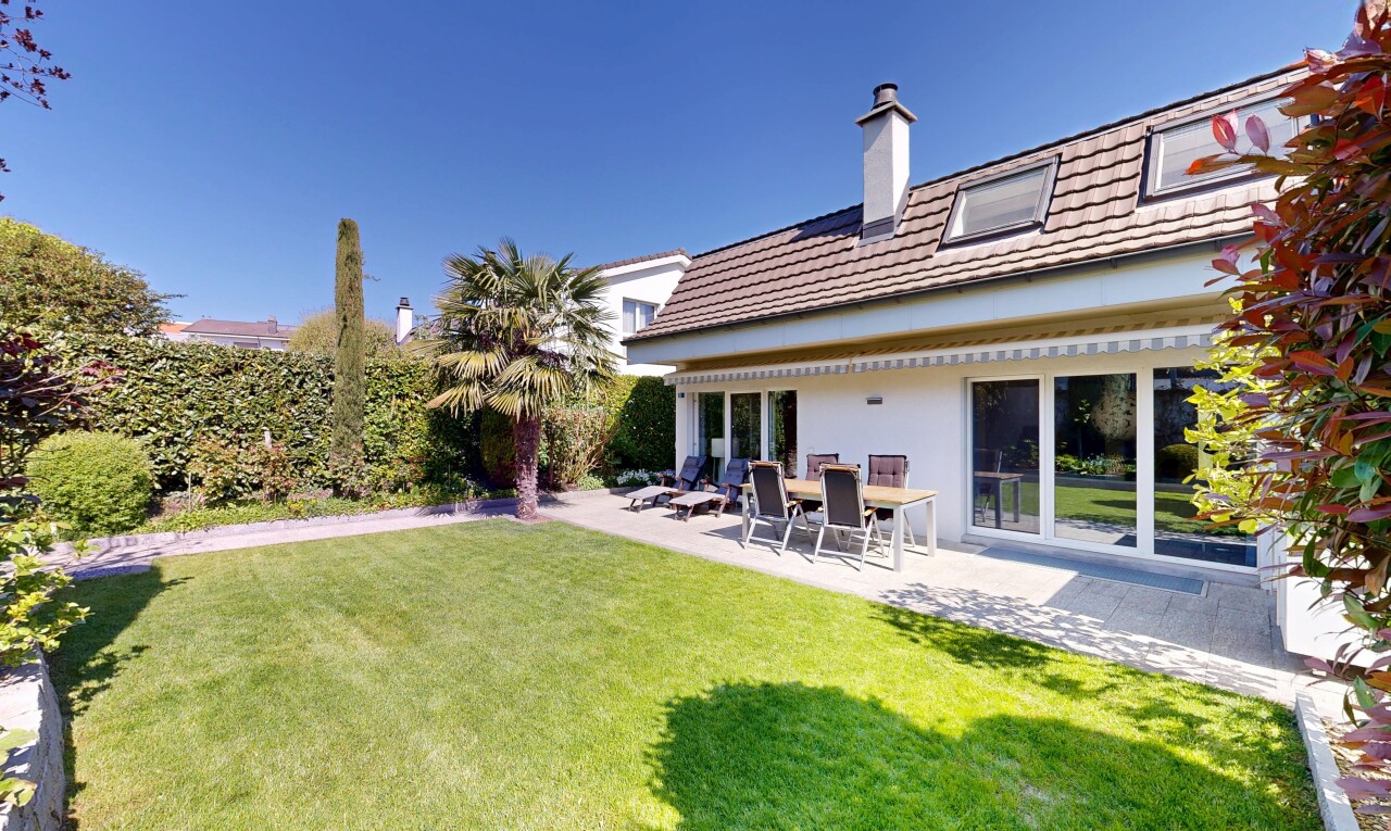 view of property with a patio area, a lawn, a chimney, and stucco siding
