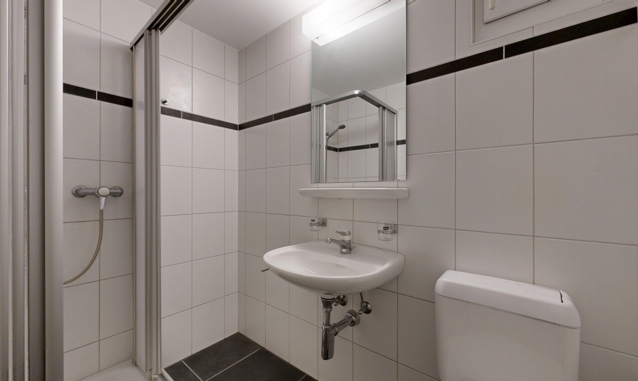 bathroom with a stall shower and tile walls