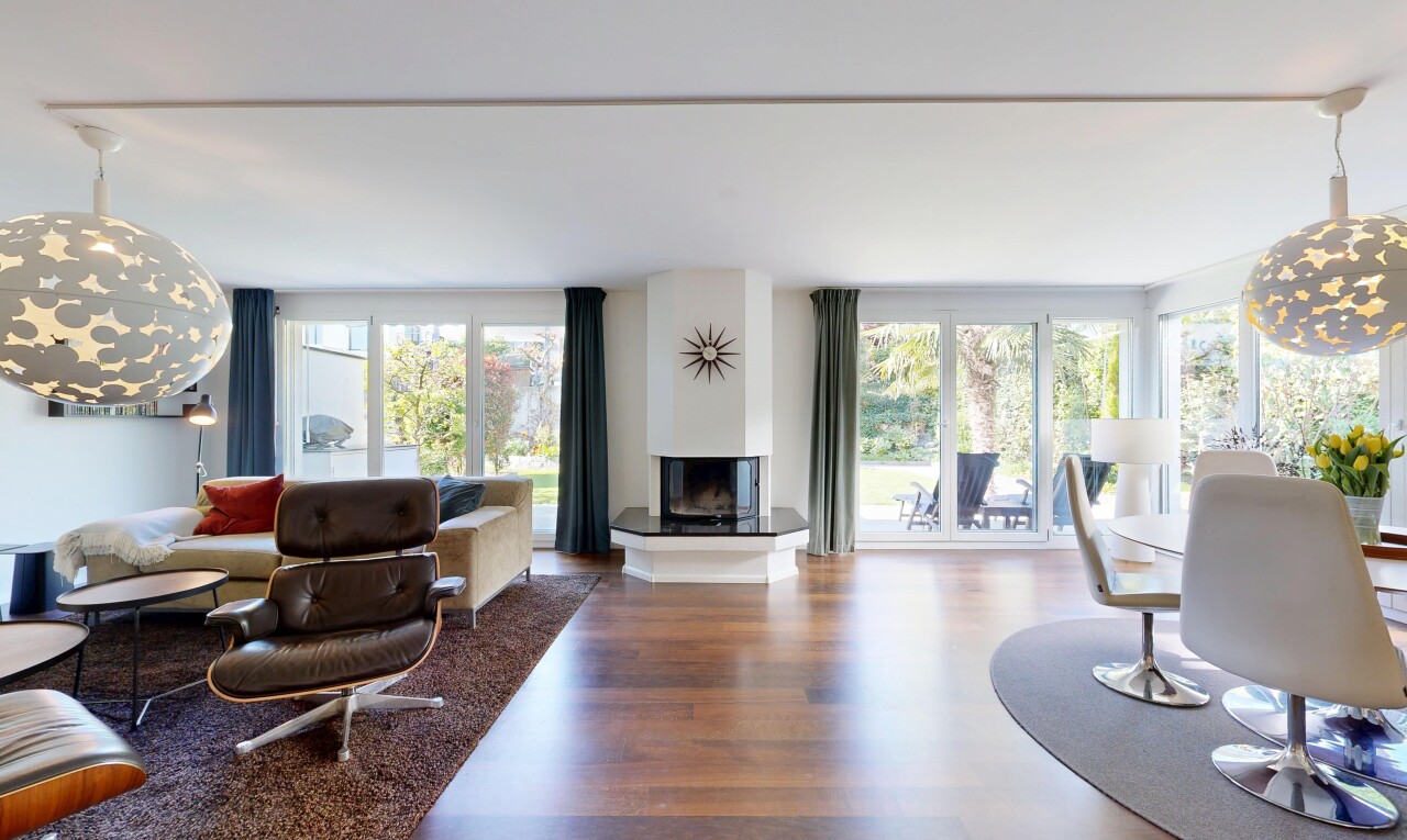 living room with wood finished floors, plenty of natural light, and a multi sided fireplace