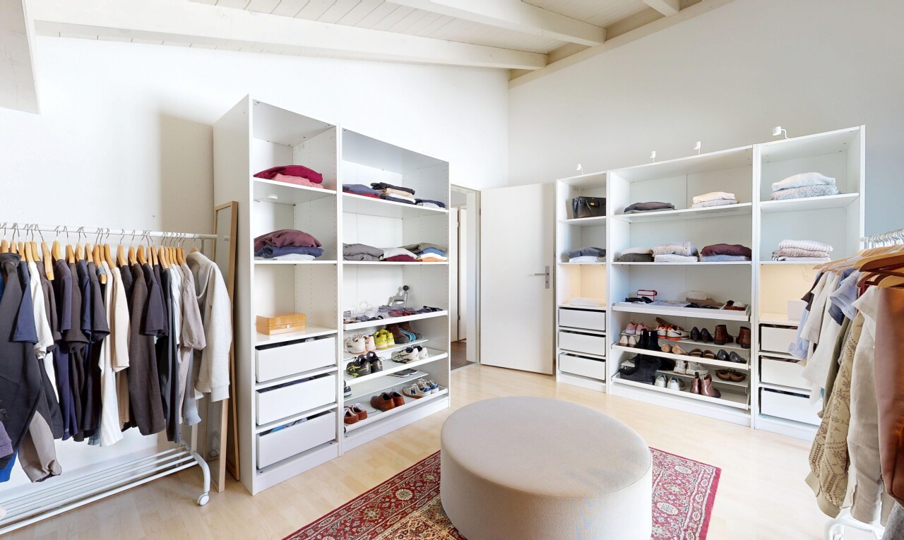 walk in closet with light wood finished floors