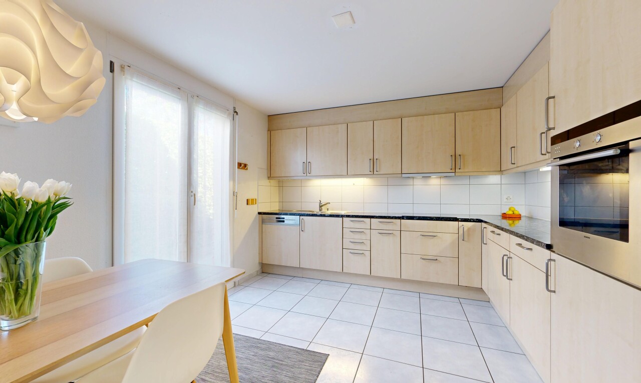 kitchen with light wood finish cabinets, oven, backsplash, and light tile patterned floors