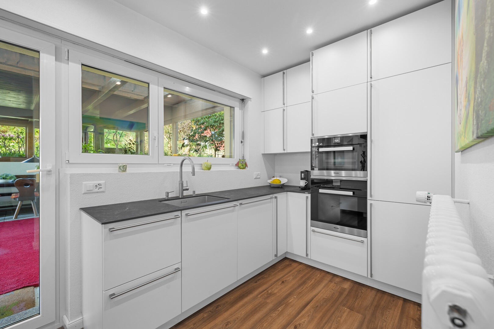 cuisine avec radiateur, four double, évier, et plans de travail