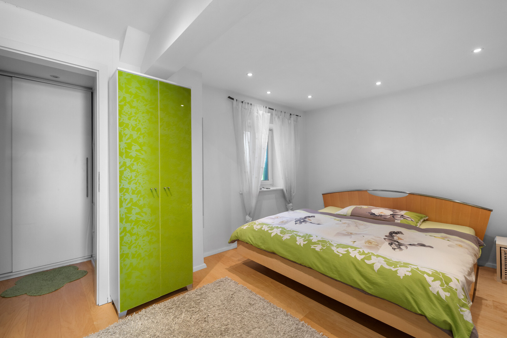 chambre avec sol en finition bois, lumière naturelle, cloison sèche, et éclairage encastré