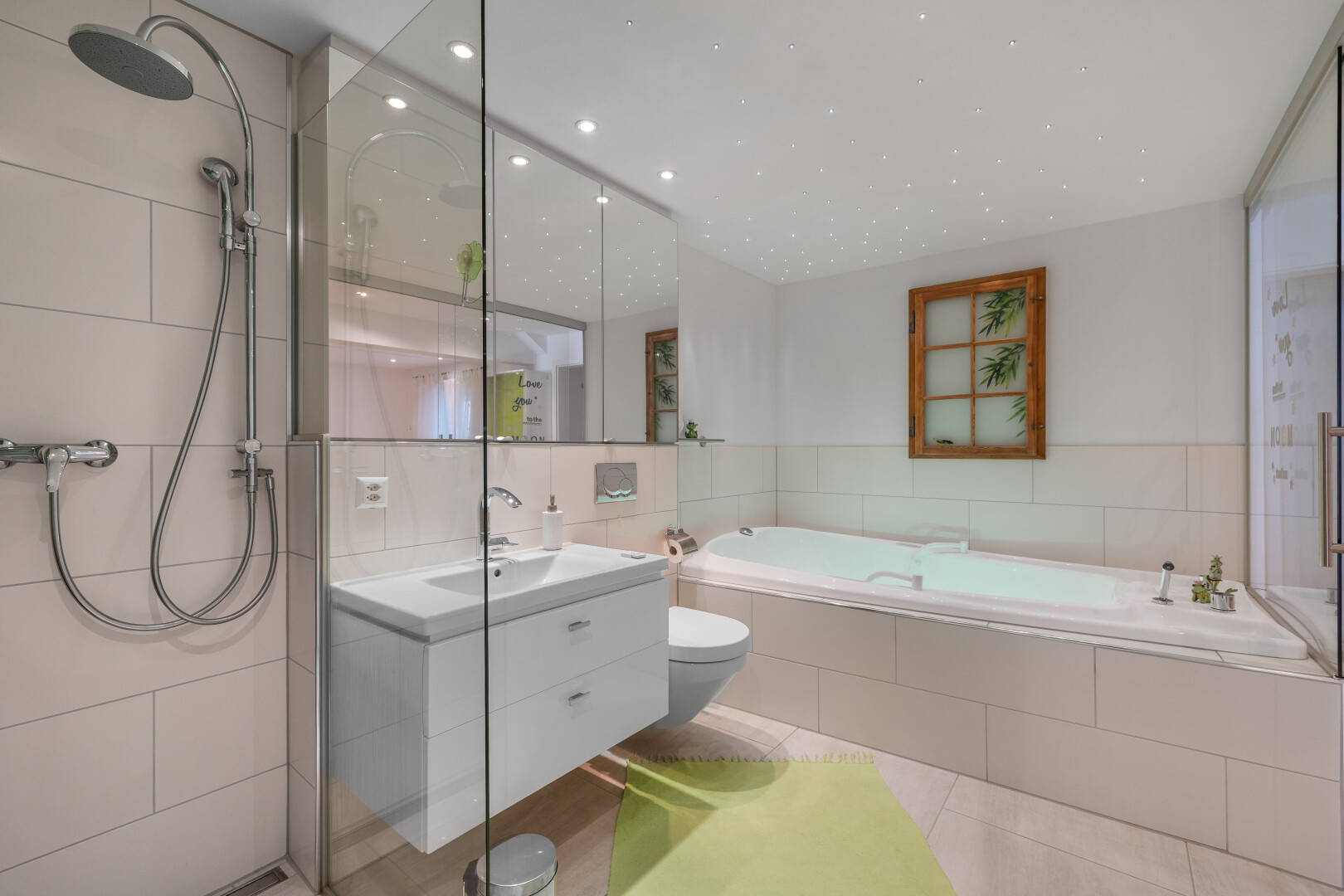 salle de bains avec lavabo (ou coiffeuse selon le contexte), évier, bain, mur en carrelage, et toilette