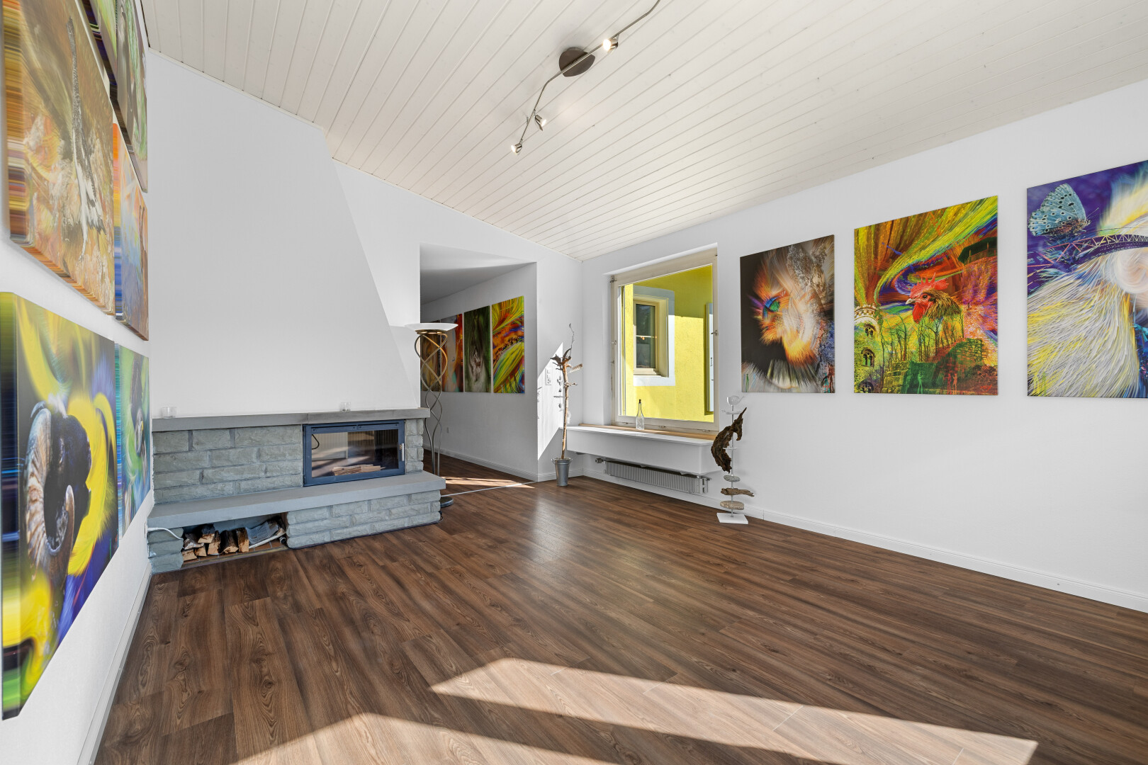 salon avec sol en finition bois, cheminée, plinthes murales, cloison sèche, et plafond voûté