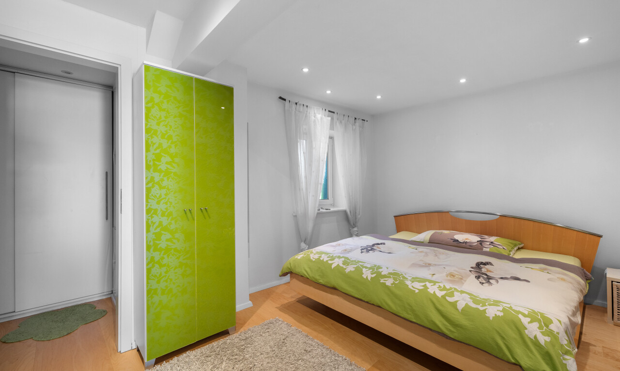 chambre avec sol en finition bois, lumière naturelle, cloison sèche, et éclairage encastré
