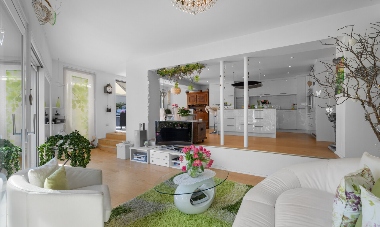 wohnzimmer mit bemerkenswerter kronleuchter, fernseher, holzfußboden, und gipskartonwand