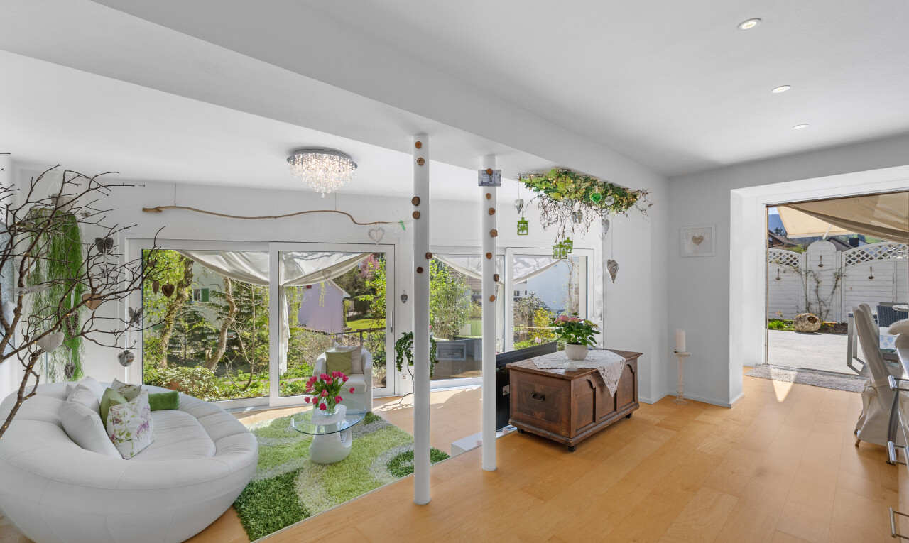 innenraum mit natürliches licht, bemerkenswerter kronleuchter, holzfußboden, einbauleuchten, und gipskartonwand