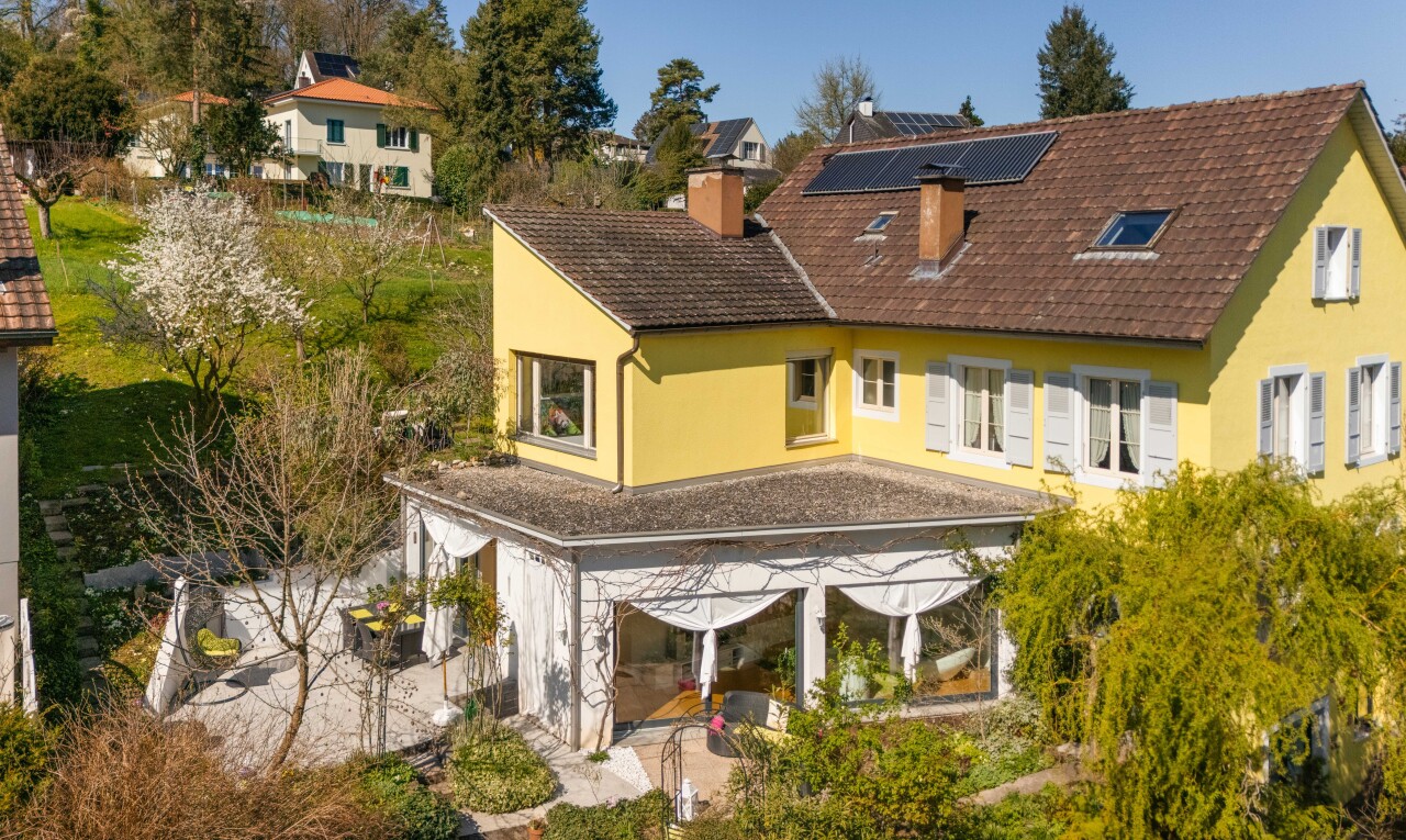 façade avec bardage en stuc, panneaux solaires, cheminée, et toit en bardeaux