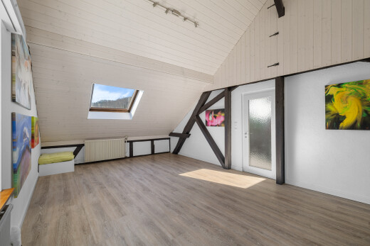 pièce vide avec puits de lumière, pièce supplémentaire, plafond voûté, et sol en finition bois