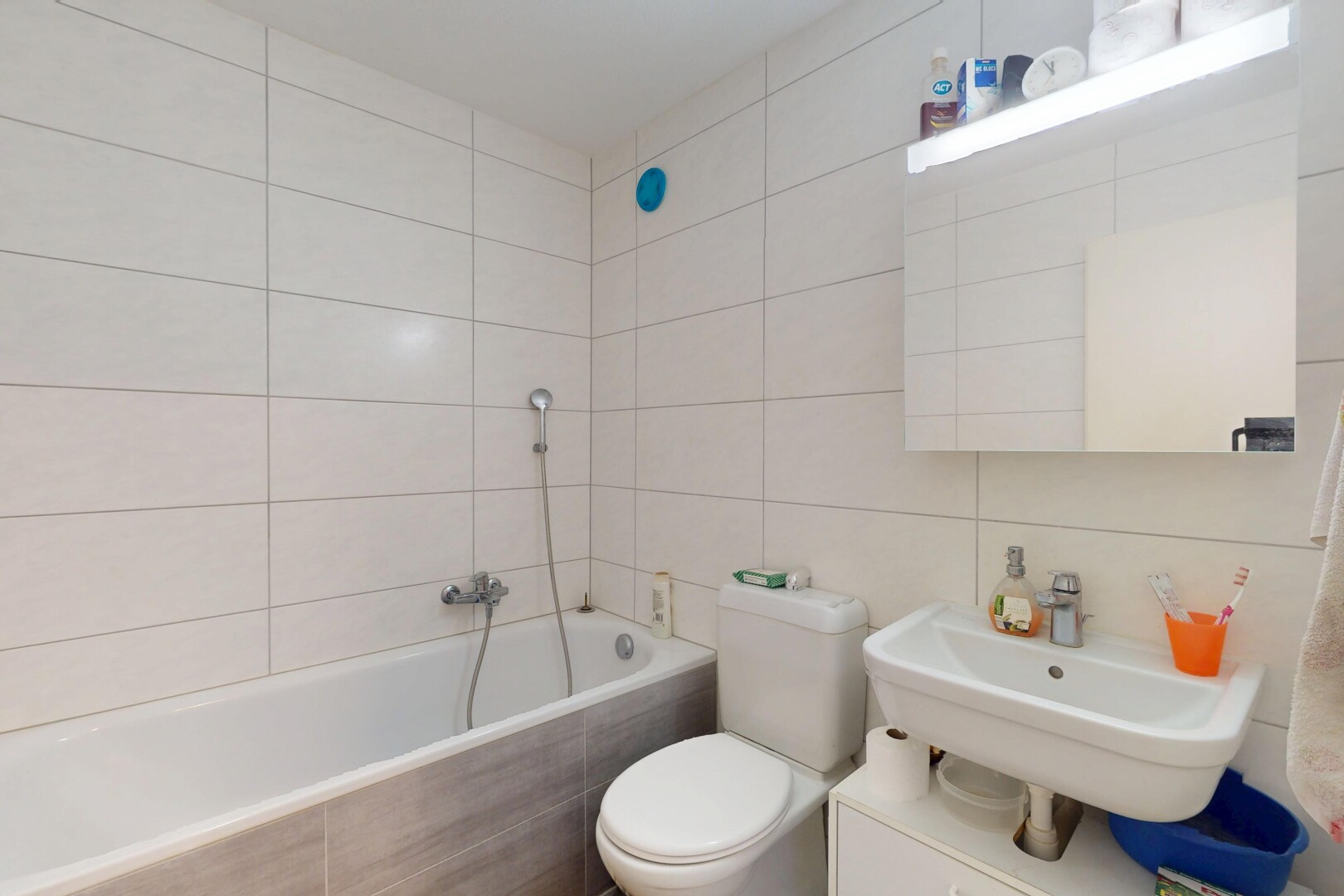 salle de bains avec évier, mur en carrelage, salle de bain complète, bain, et toilette