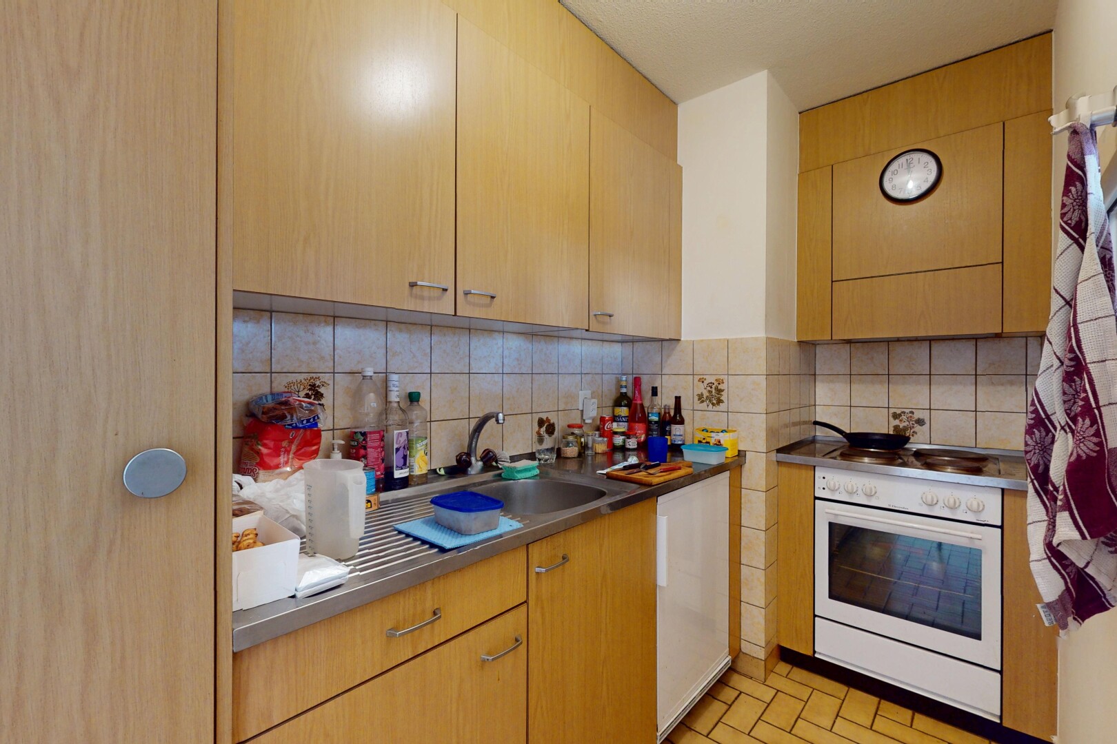 cuisine avec dosseret, four, évier, et plaque de cuisson