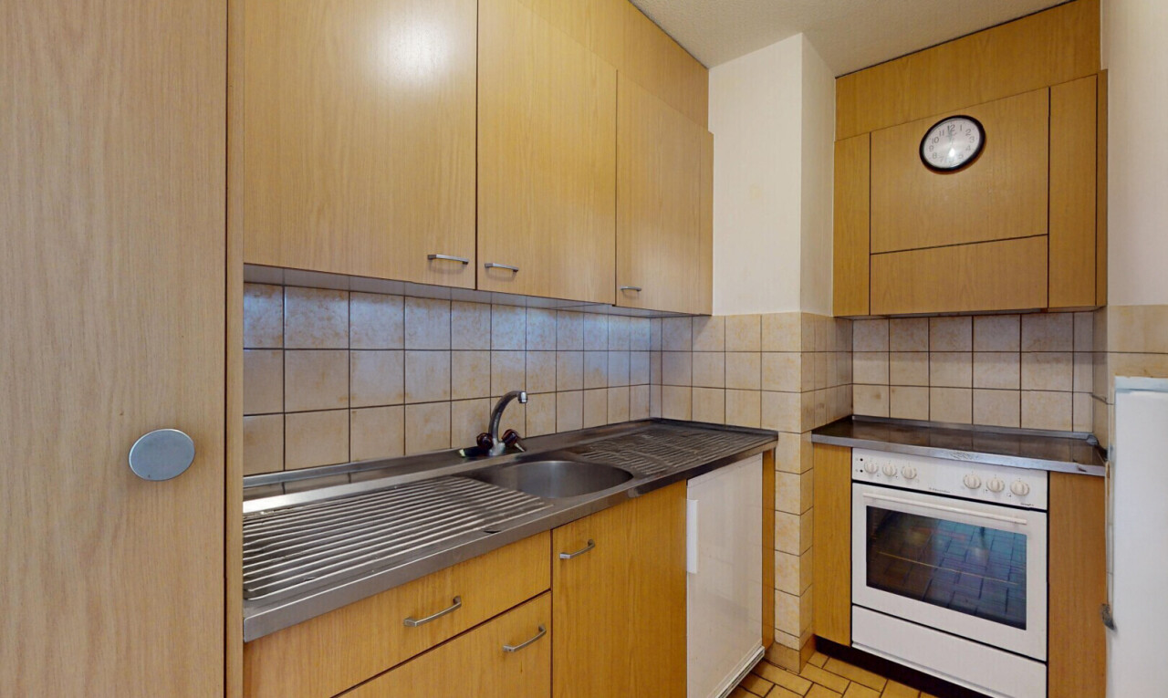 cuisine avec dosseret, four, évier, et plaque de cuisson
