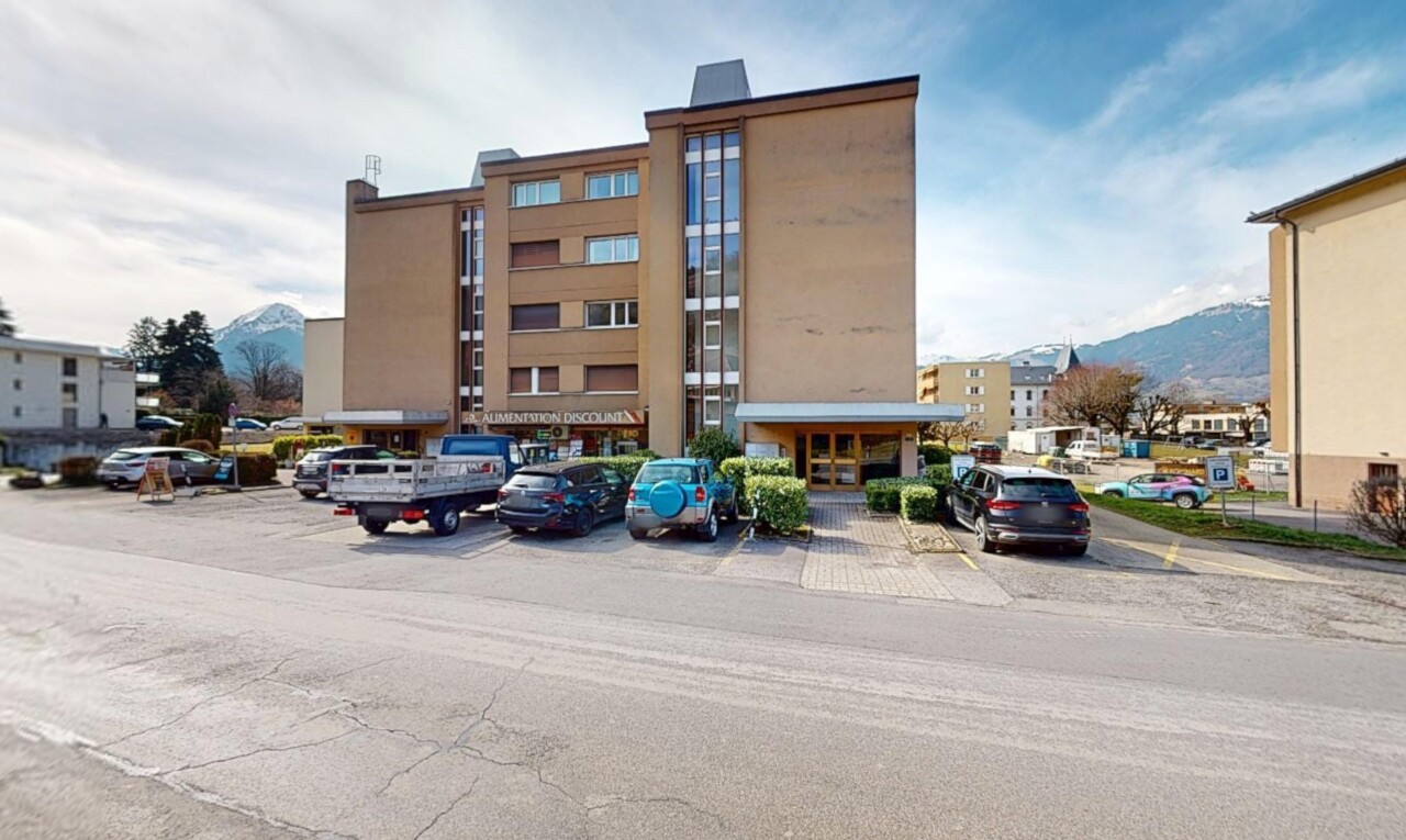 extérieur du bâtiment avec parking et vue sur la montagne