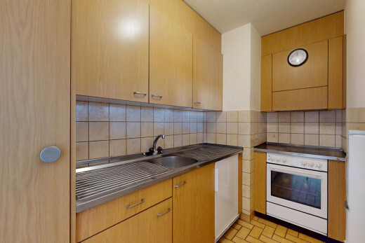 küche mit ofen, arbeitsplatten, küchenrückwand beim herd, und ziegelfußboden