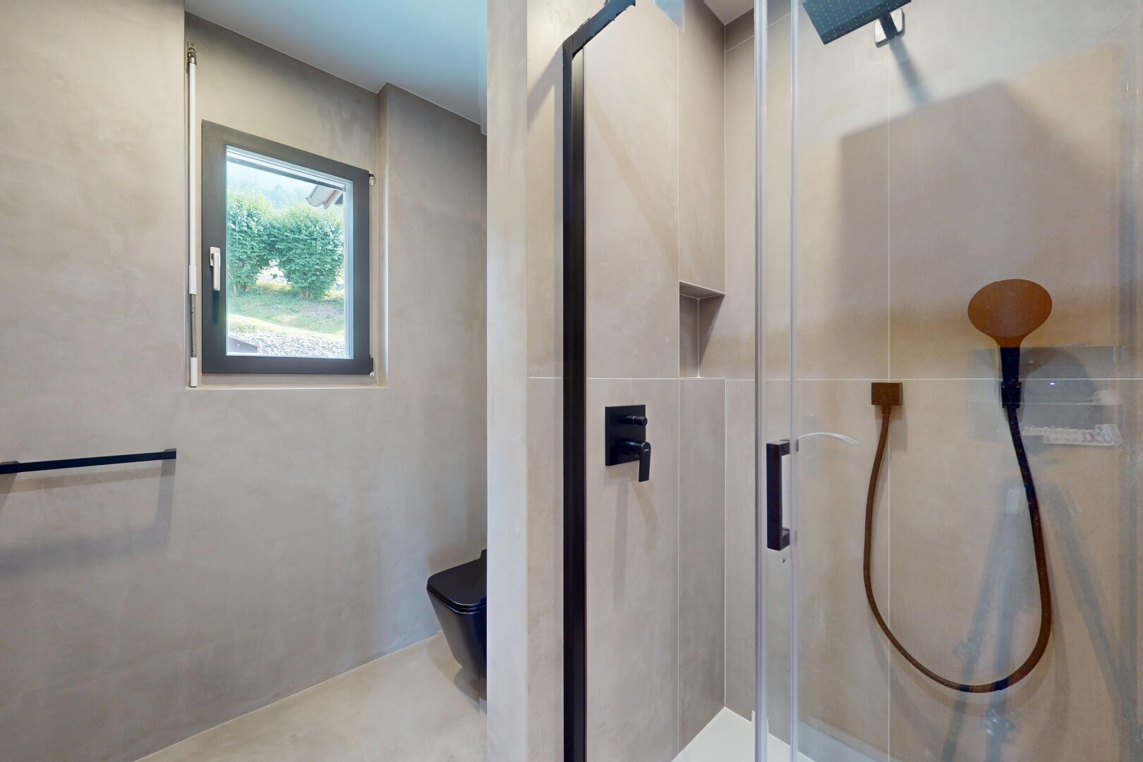 bathroom with a shower stall and tile walls