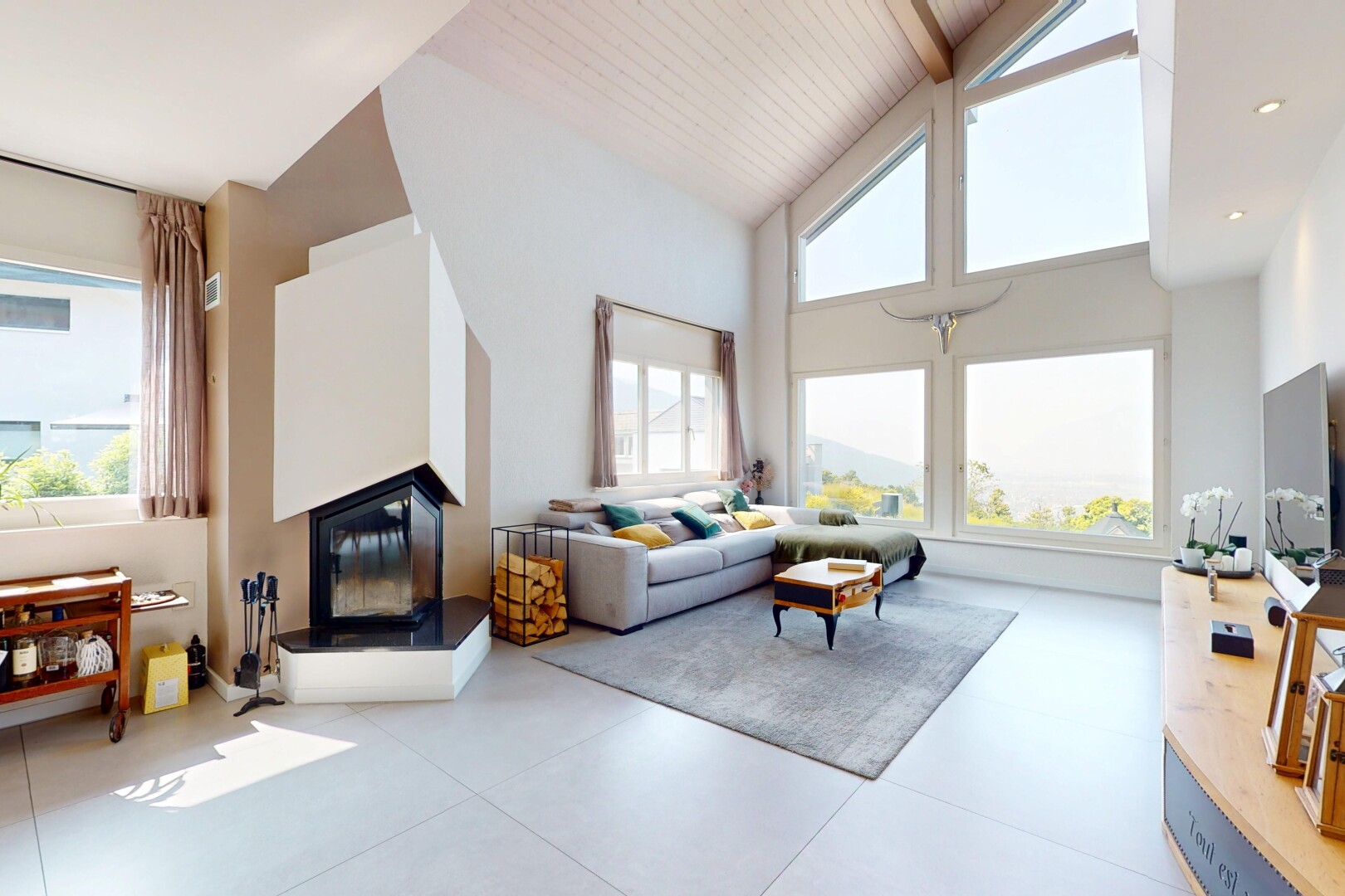 living room featuring high vaulted ceiling, a glass covered fireplace, and healthy amount of natural light