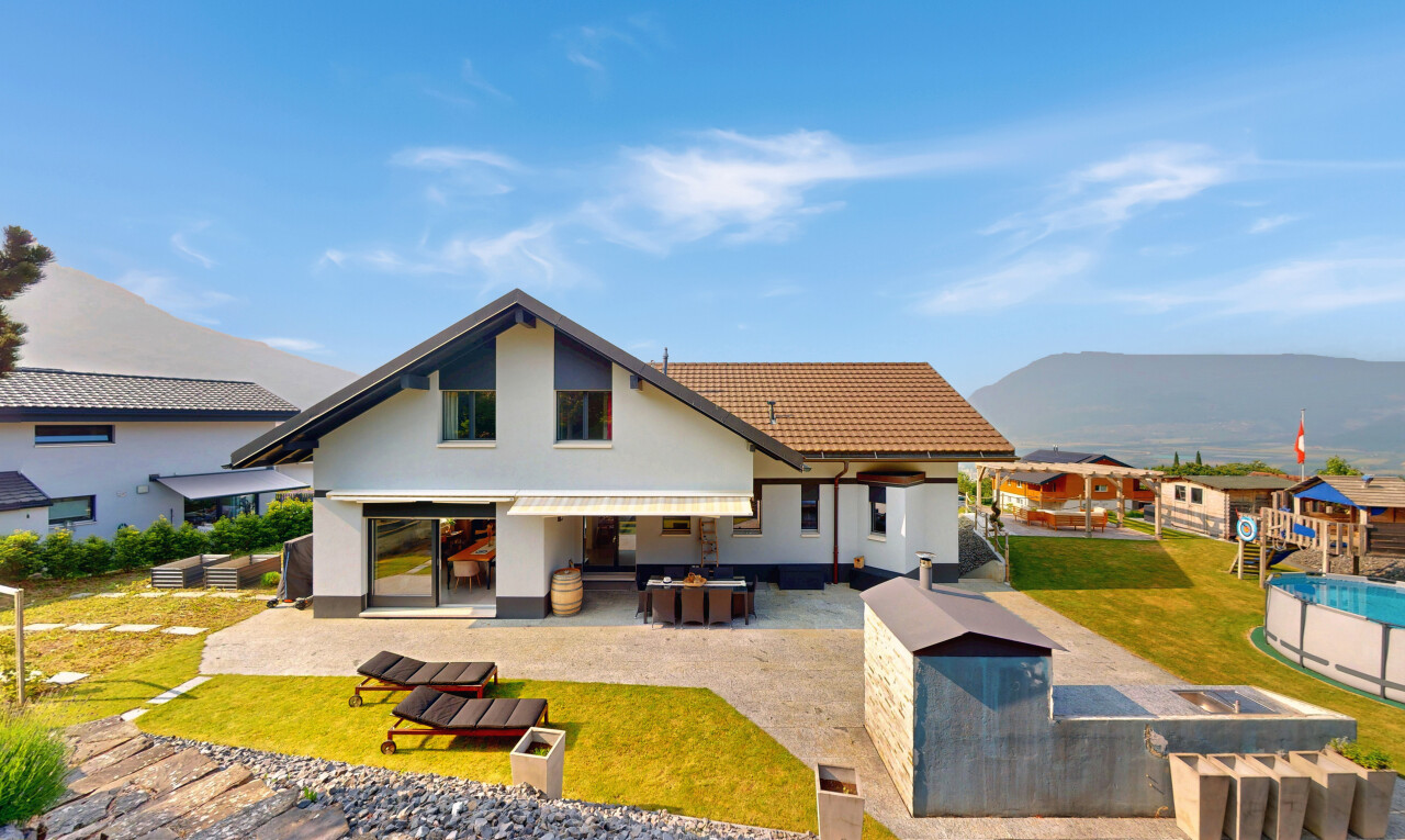 outdoor house with a patio area, a mountain view, stucco siding, a yard, and a tile roof