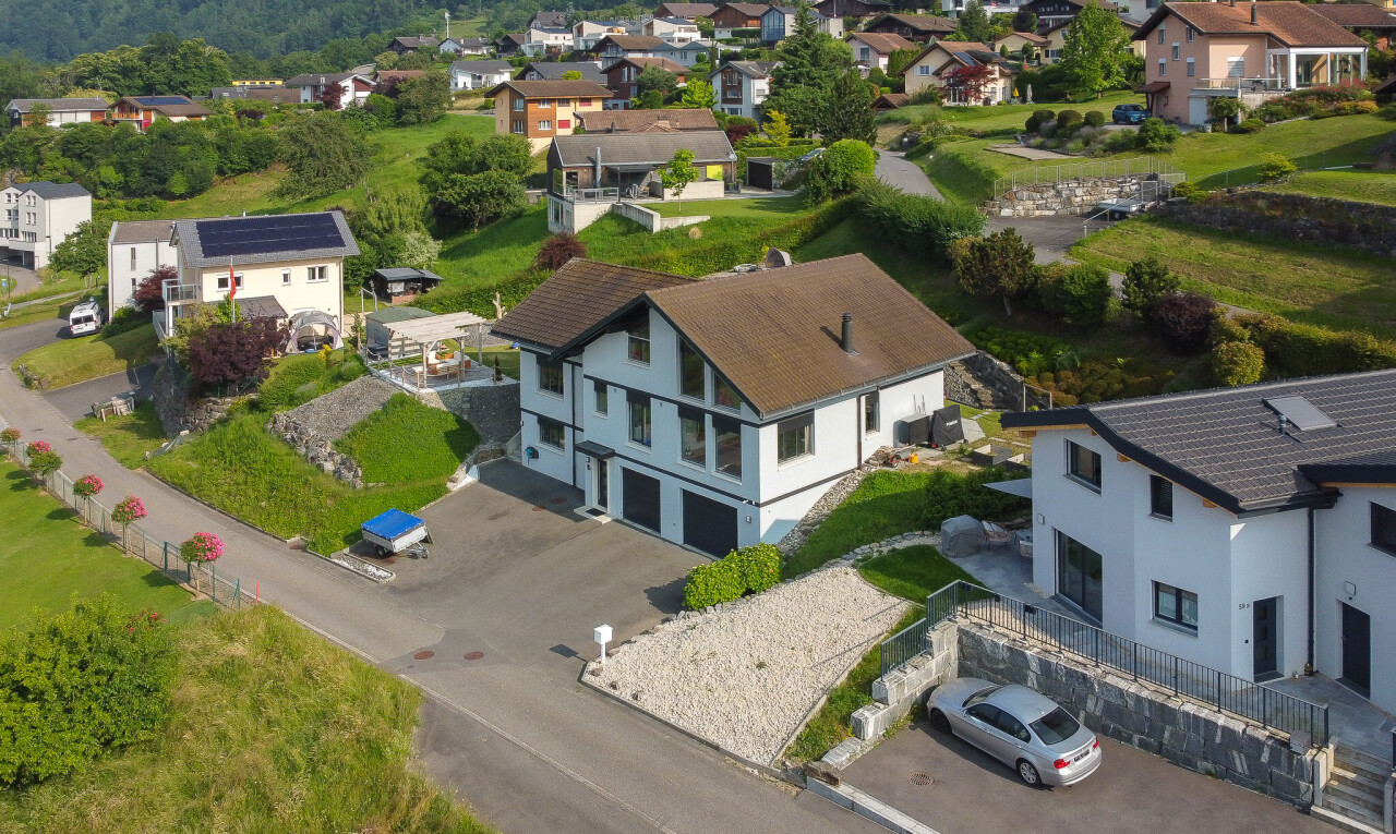 view of property with driveway, a residential view, an attached garage, and stucco siding