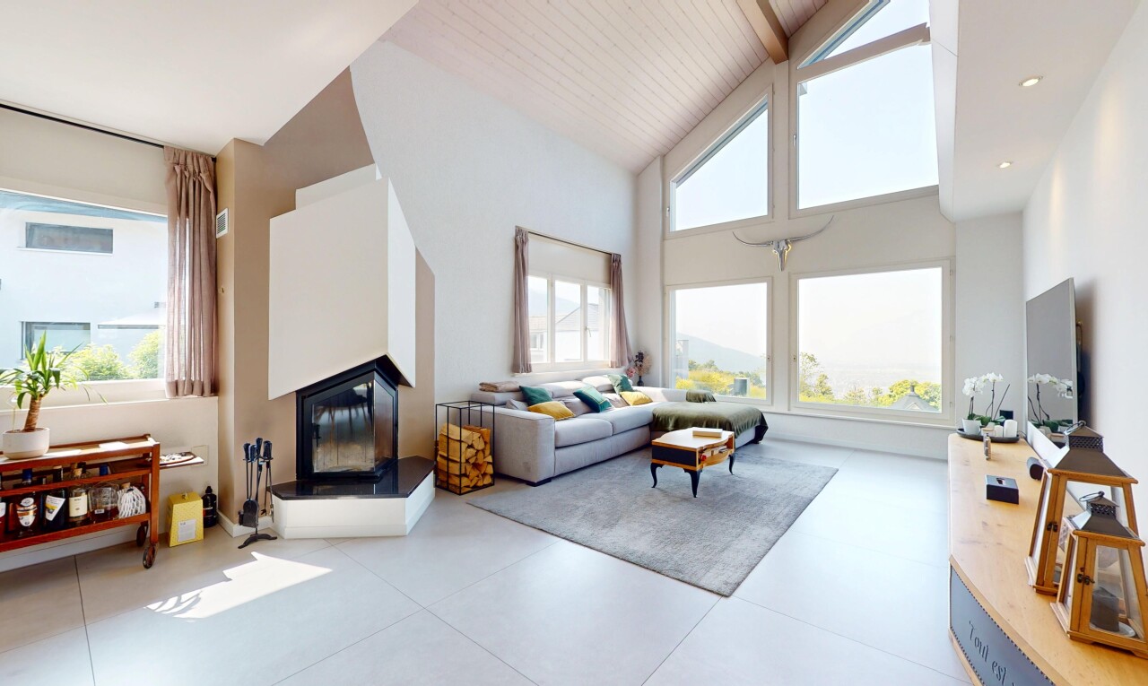 living room featuring high vaulted ceiling, a glass covered fireplace, and healthy amount of natural light