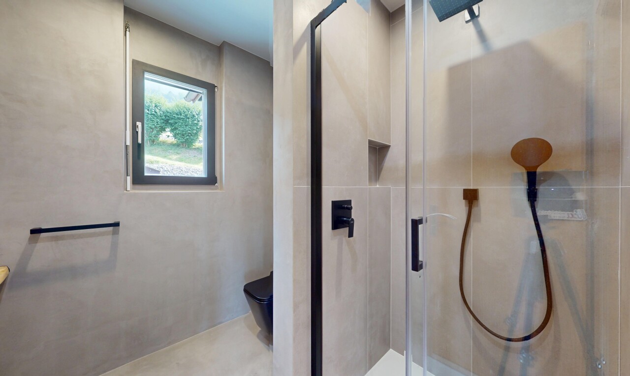bathroom with a shower stall and tile walls