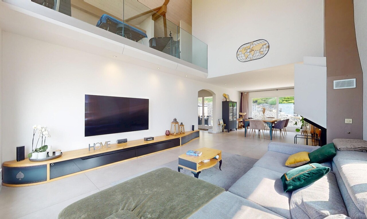 living room featuring a high ceiling, arched walkways, a fireplace, and tile patterned flooring