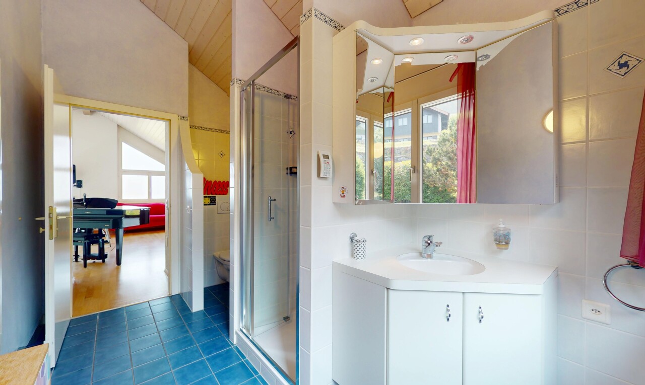 bathroom with plenty of natural light, vaulted ceiling, a shower stall, vanity, and tile patterned floors