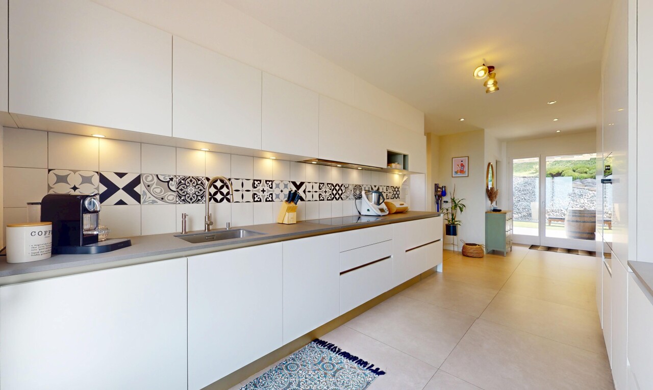 kitchen featuring backsplash, modern cabinets, white cabinetry, and light tile patterned floors