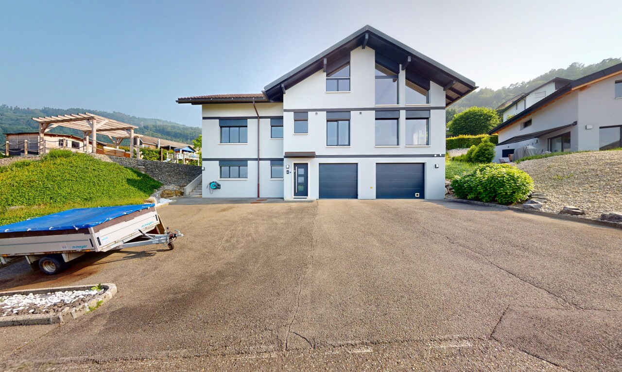 view of property with a garage, stucco siding, and driveway