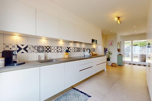 cuisine avec évier, dosseret, backsplash, inside property, et armoires à panneau plat