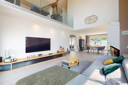 salon / salle à manger avec télévision, plafond haut, high ceiling, passages en arc, et lumière naturelle
