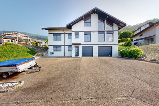 façade avec property visible, garage intégré, bardage en stuc, et allée