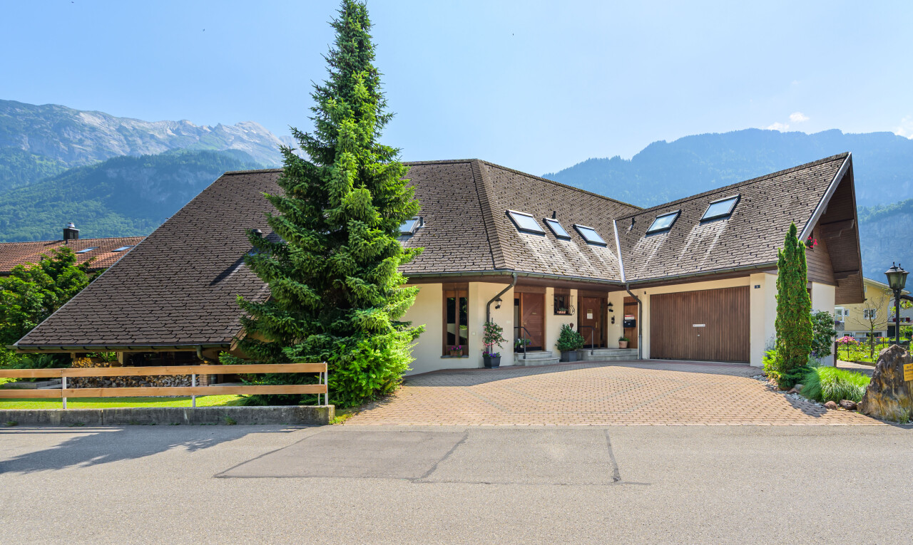 außenansicht mit auffahrt, blick auf die berge, mountain view, property visible, und garage angeschlossen