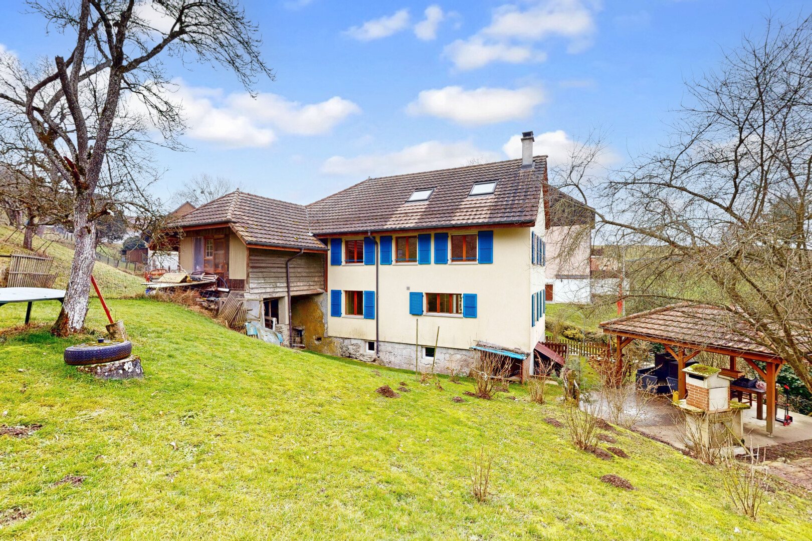 außenansicht mit schornstein, rasen, property visible, terrasse, und stuckverkleidung