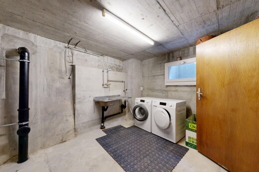 buanderie avec sous-sol, plafond en béton, concrete ceiling, sol en béton, et concrete floor