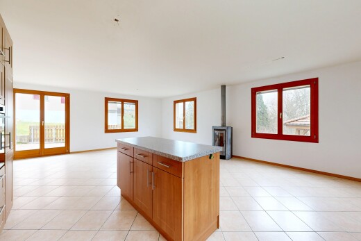 cuisine avec poêle à bois, medium brown cabinets, armoires marron moyen, opens to living area, et ouvert sur l'espace de vie
