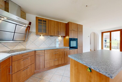 cuisine avec hotte, glass insert cabinets, armoires avec insert en verre, passages en arc, et medium brown cabinets