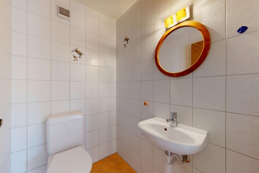 salle de bains avec miroir, tile wall, mur en carrelage, toilette, et évier