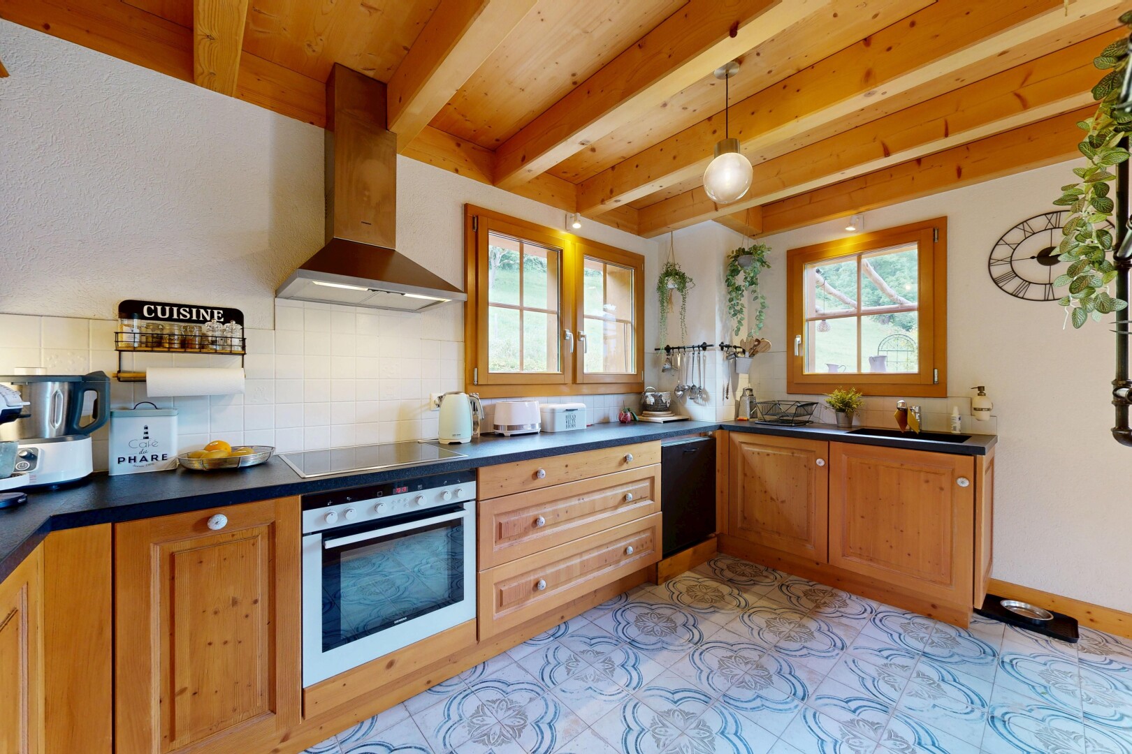 cuisine avec hotte, four, plans de travail, dark countertops, et dosseret