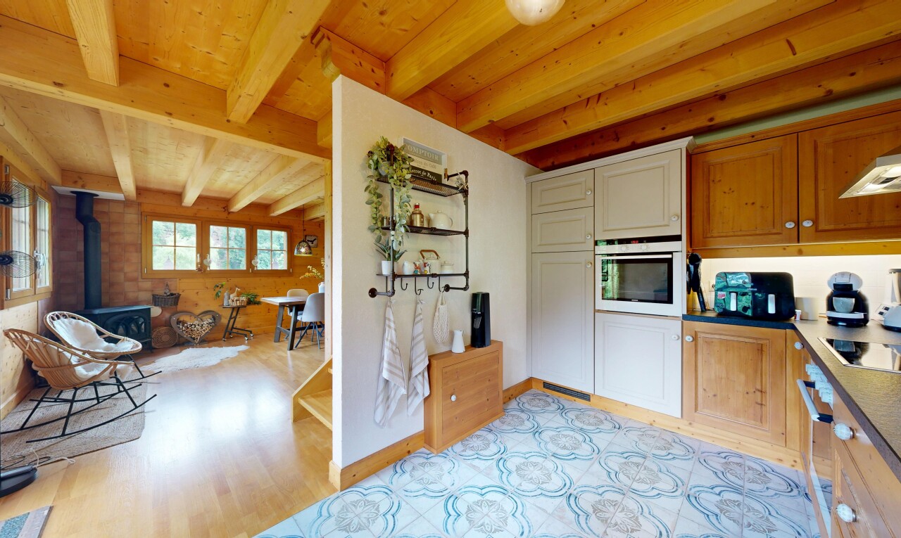cuisine avec four, poêle à bois, light floor, inside property, et plafond à poutres