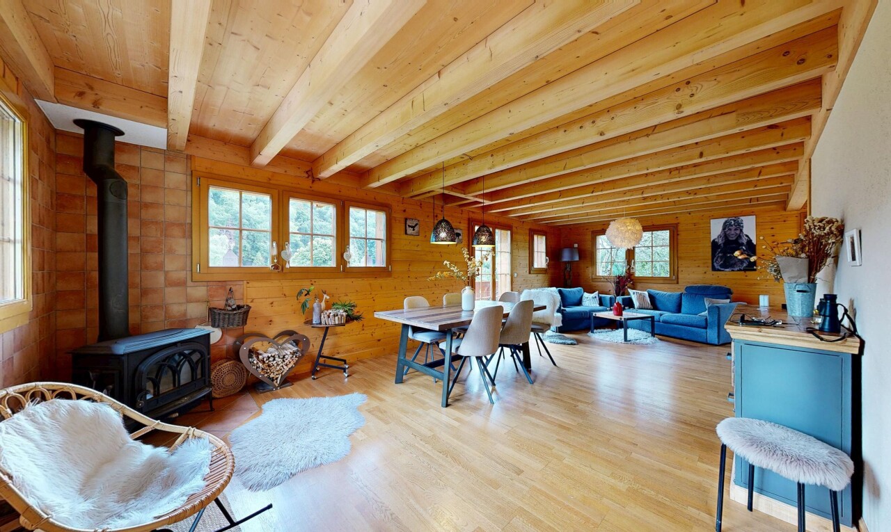 salon / salle à manger avec poêle à bois, inside property, mur en bois, wood wall, et sol en finition bois