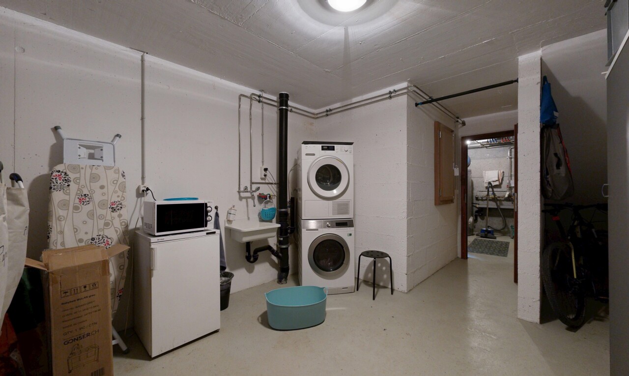 buanderie avec sous-sol, lave-linge et sèche-linge superposés, sol en béton, concrete floor, et inside property