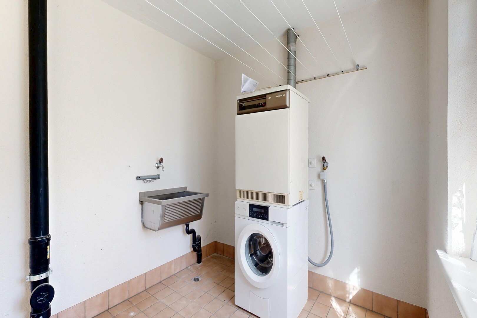 buanderie avec inside property, light floor, drywall, cloison sèche, et buanderie