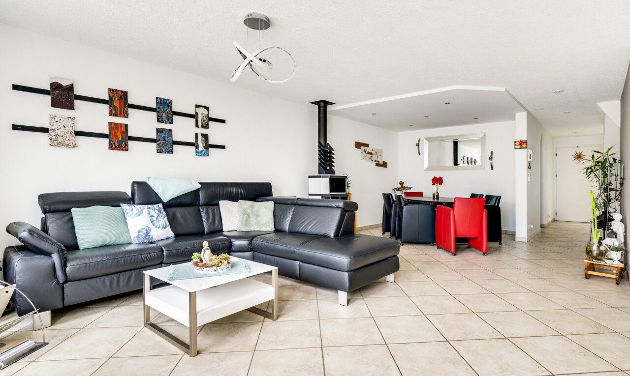 wohnzimmer mit holzofen, inside community, tile floor, fliesenboden, und drywall