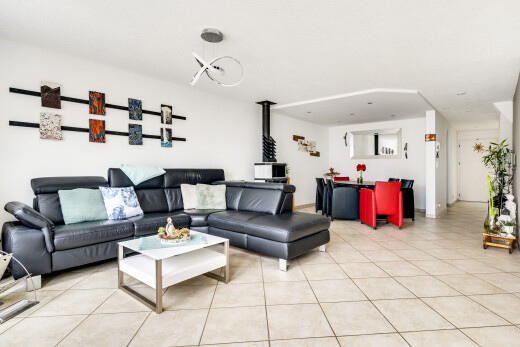 wohnzimmer mit holzofen, inside community, tile floor, fliesenboden, und drywall