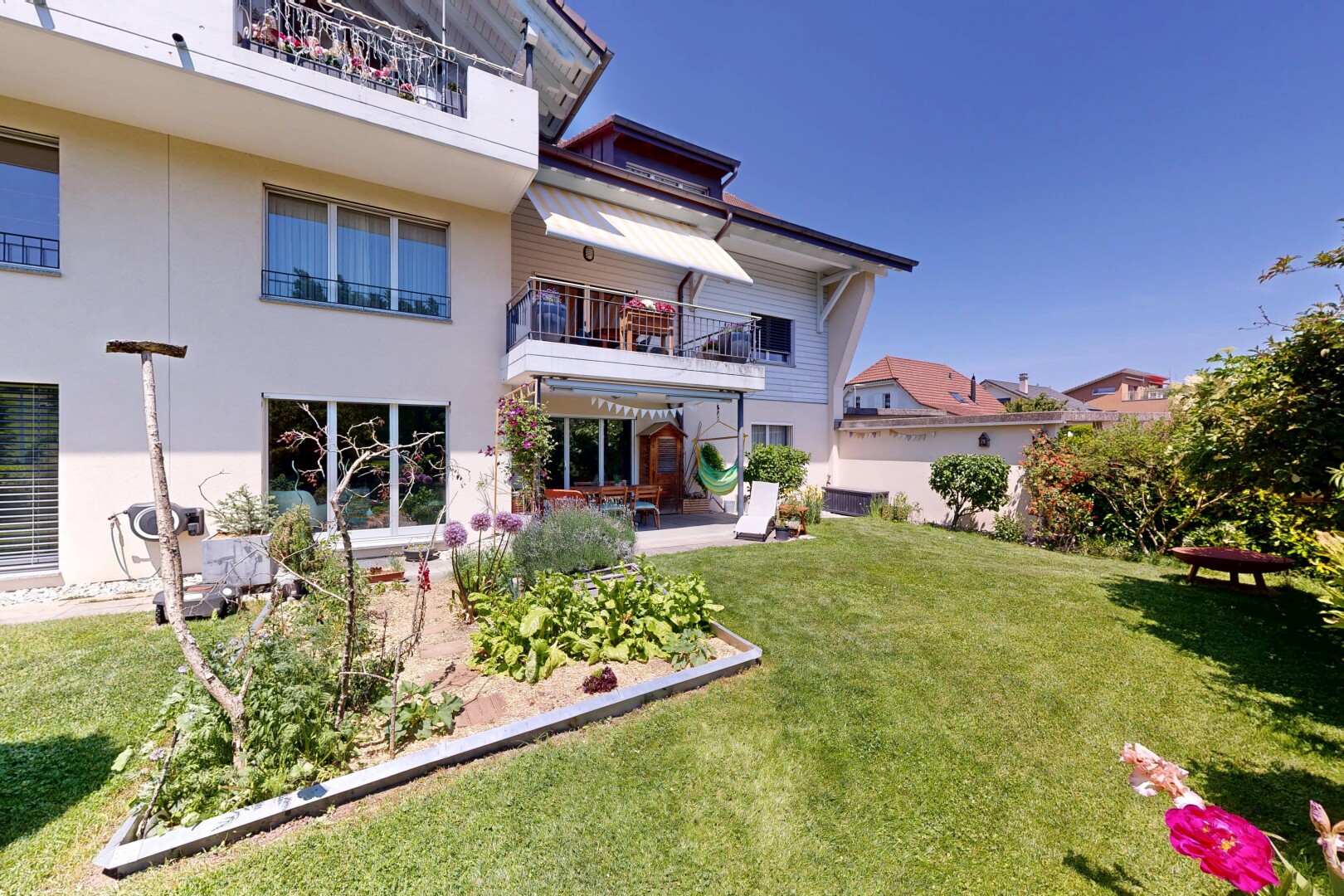 façade avec balcon, terrasse, bardage en stuc, pelouse, et day time