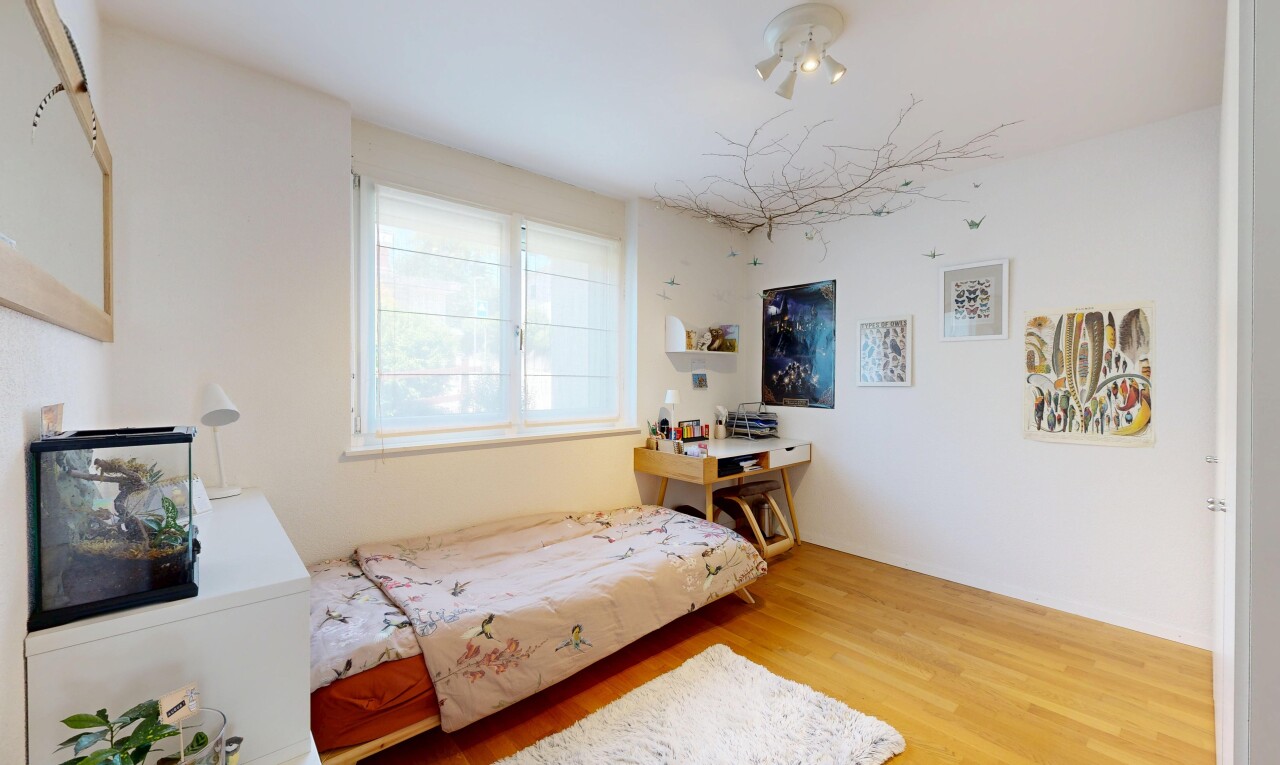 chambre avec cloison sèche, drywall, sol en finition bois, wood finish floor, et lumière naturelle