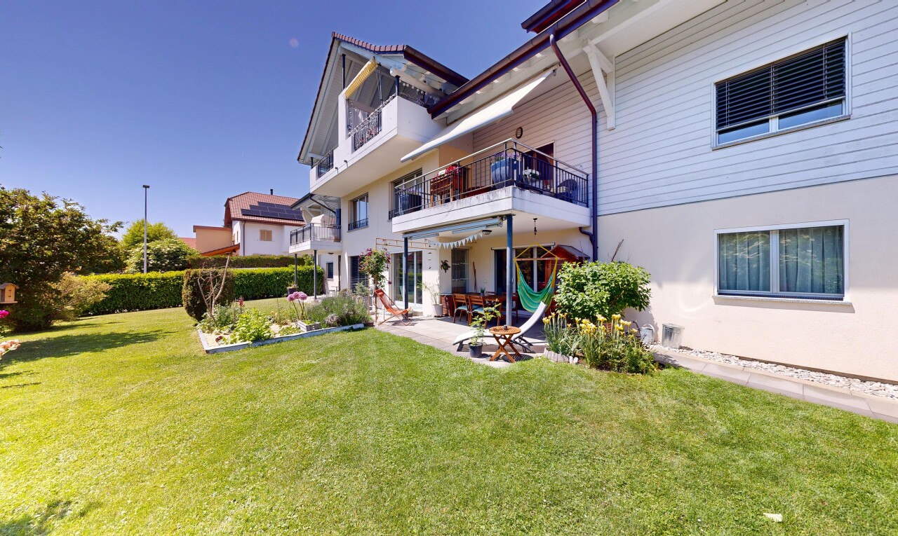 façade avec property visible, bardage horizontal, pelouse, balcon, et terrasse