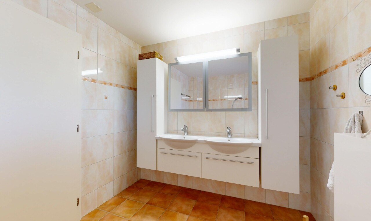 salle de bains avec miroir, double vasque, inside property, light floor, et salle de bain complète
