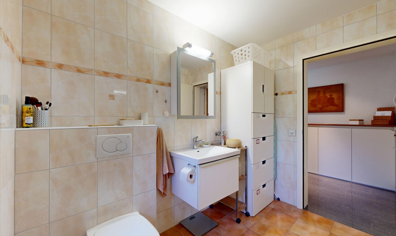 salle de bains avec mur en carrelage, tile wall, lavabo (ou coiffeuse selon le contexte), miroir, et inside property